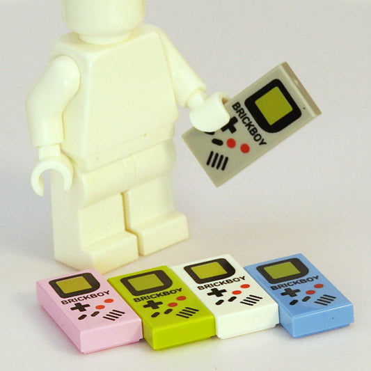 Toy figure holding a remote control with 'BRICKBOY' branding, surrounded by colorful 'BRICKBOY' products on a light background.